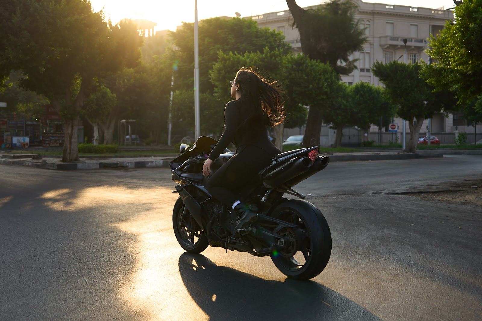 Black suit on a motorbike at sunset