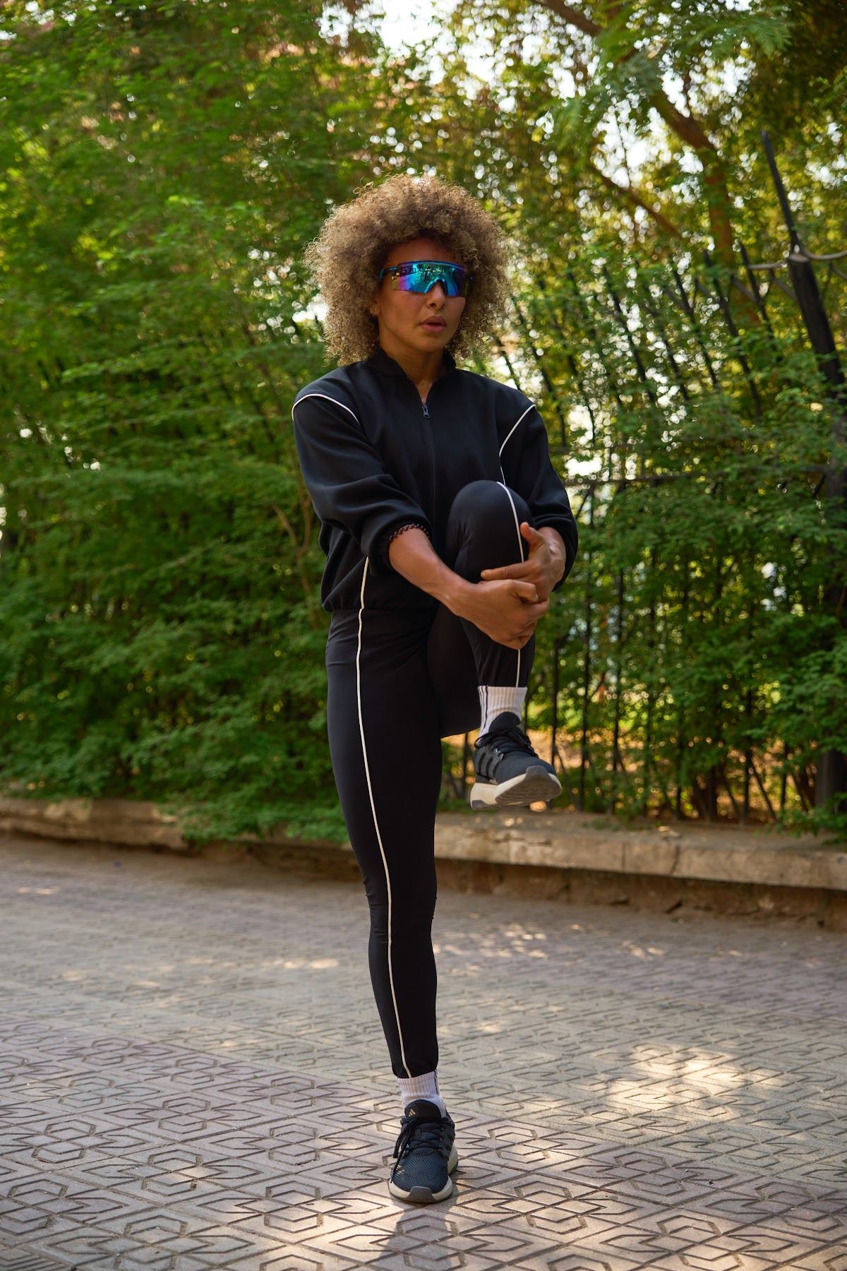 Black piped leggings, stretching under the trees